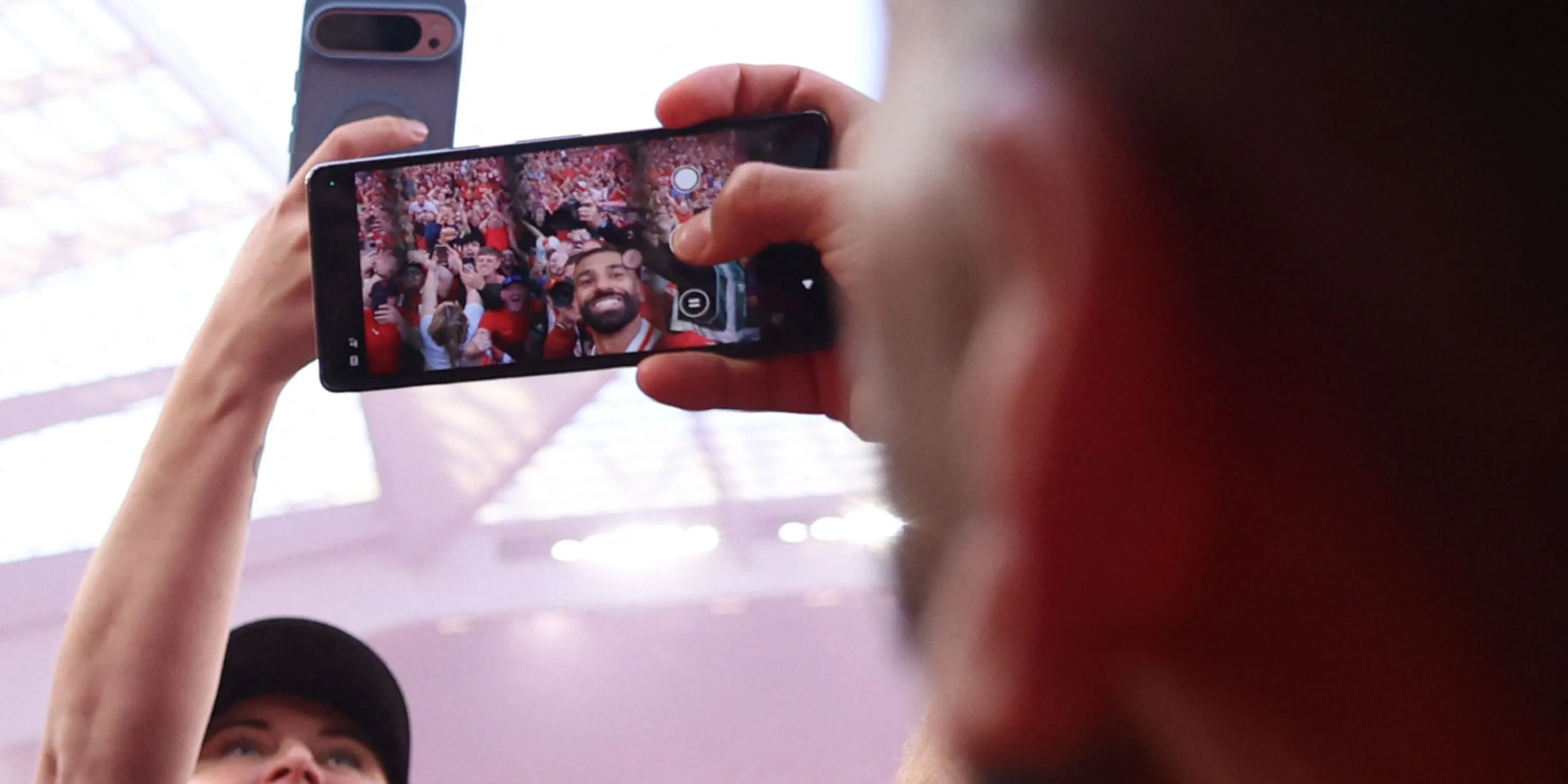 Mohamed Salah chụp ảnh selfie bằng điện thoại với CĐV Liverpool trên sân Anfield sau khi ghi bàn