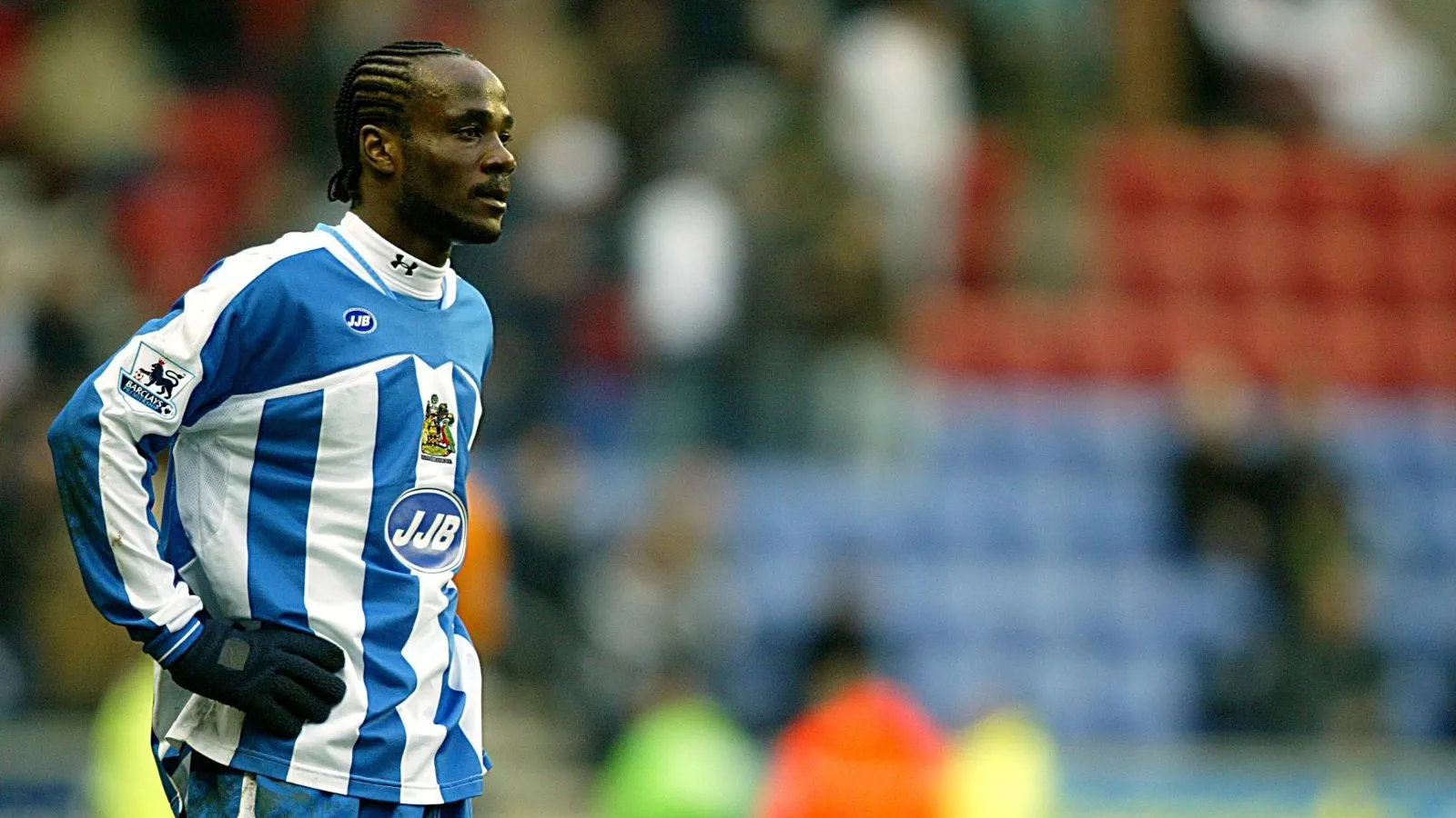 Hậu vệ Pascal Chimbonda của Wigan thi đấu với áo dài tay và găng tay