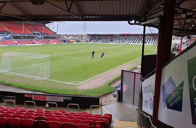 Góc nhìn từ khán đài bên trong sân Blundell Park, thể hiện không khí trận đấu và cấu trúc khán đài.