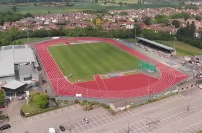 Toàn cảnh sân vận động Melbourne Stadium của Chelmsford City FC nhìn từ trên cao, thể hiện rõ đường chạy điền kinh và khán đài chính