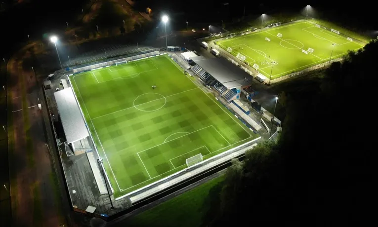 Toàn cảnh sân vận động Tameside của Curzon Ashton lung linh về đêm, làm nổi bật vẻ đẹp hiện đại của sân bóng địa phương.