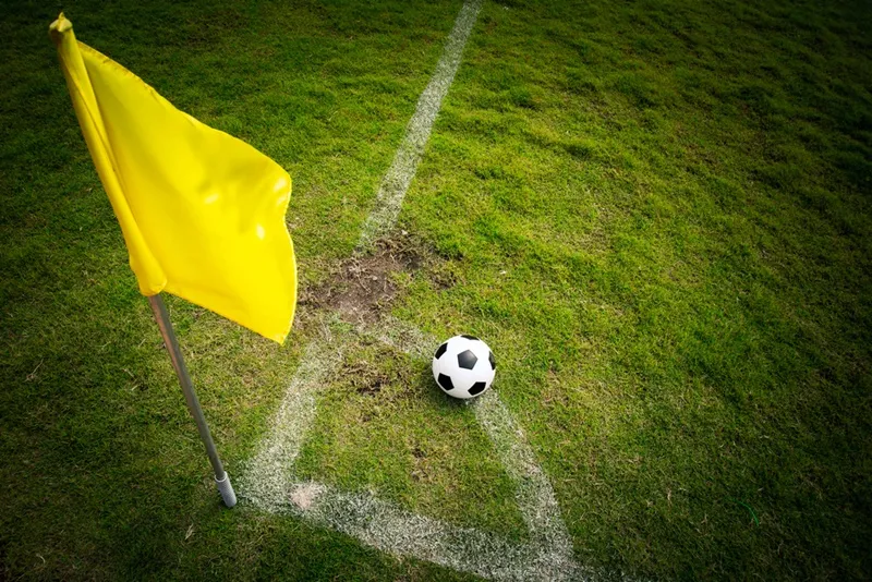 Cột cờ góc, cung tròn 1m và quy định khoảng cách phòng ngự được áp dụng trong Luật phạt góc của IFAB/FIFA.