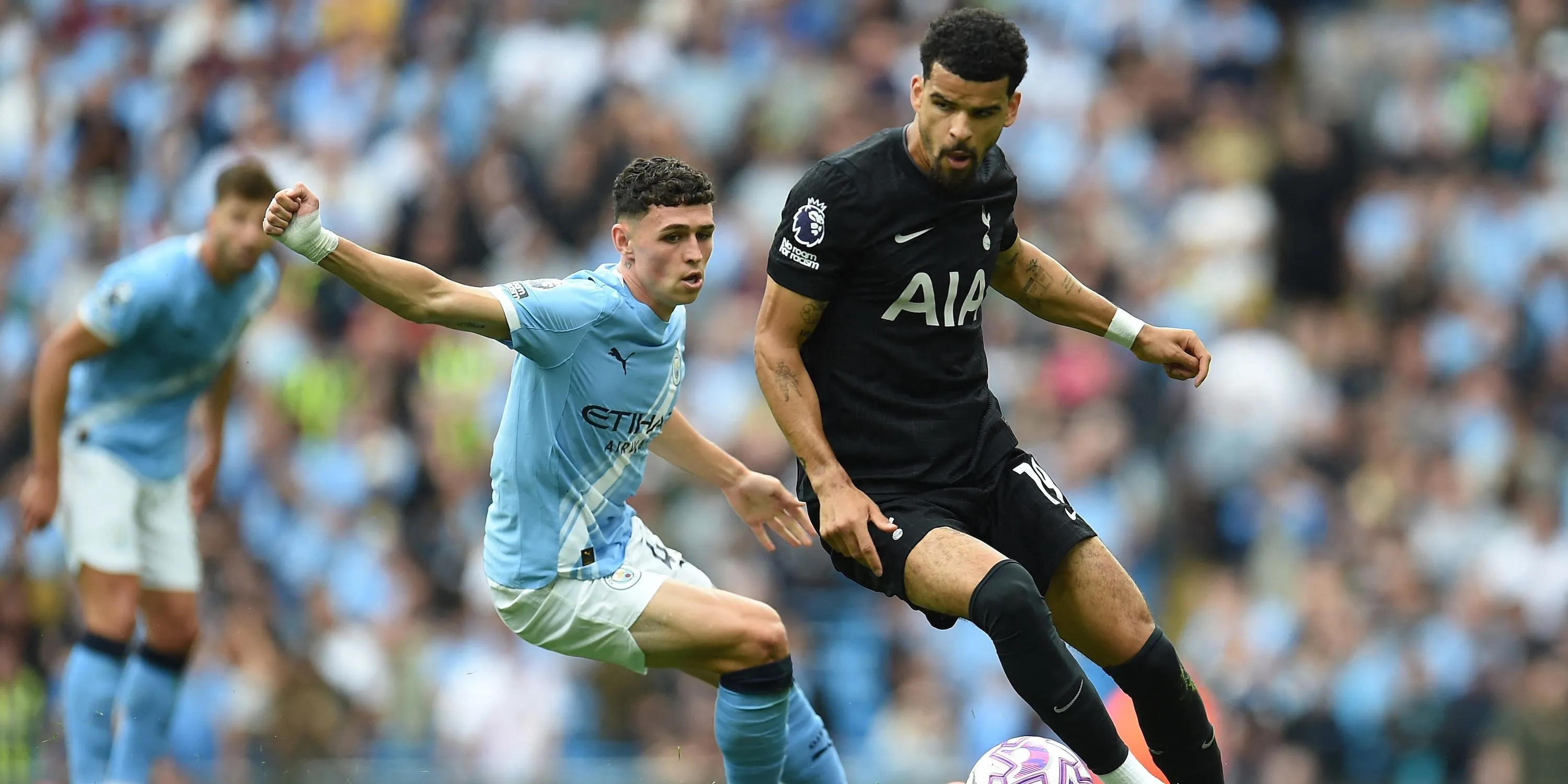 Dominic Solanke của Tottenham tranh bóng với Phil Foden — hình ảnh tiền đạo Spurs trong một pha va chạm