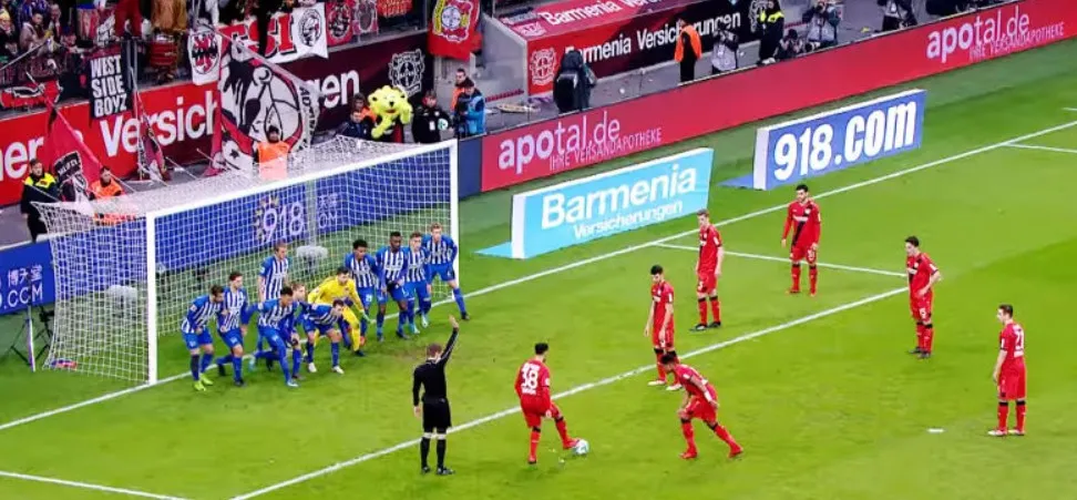 Trọng tài giơ tay báo hiệu đá phạt gián tiếp trên sân