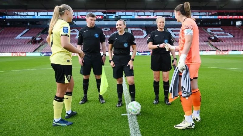 Trọng tài tung đồng xu xác định đội giao bóng tại vòng tròn trung tâm